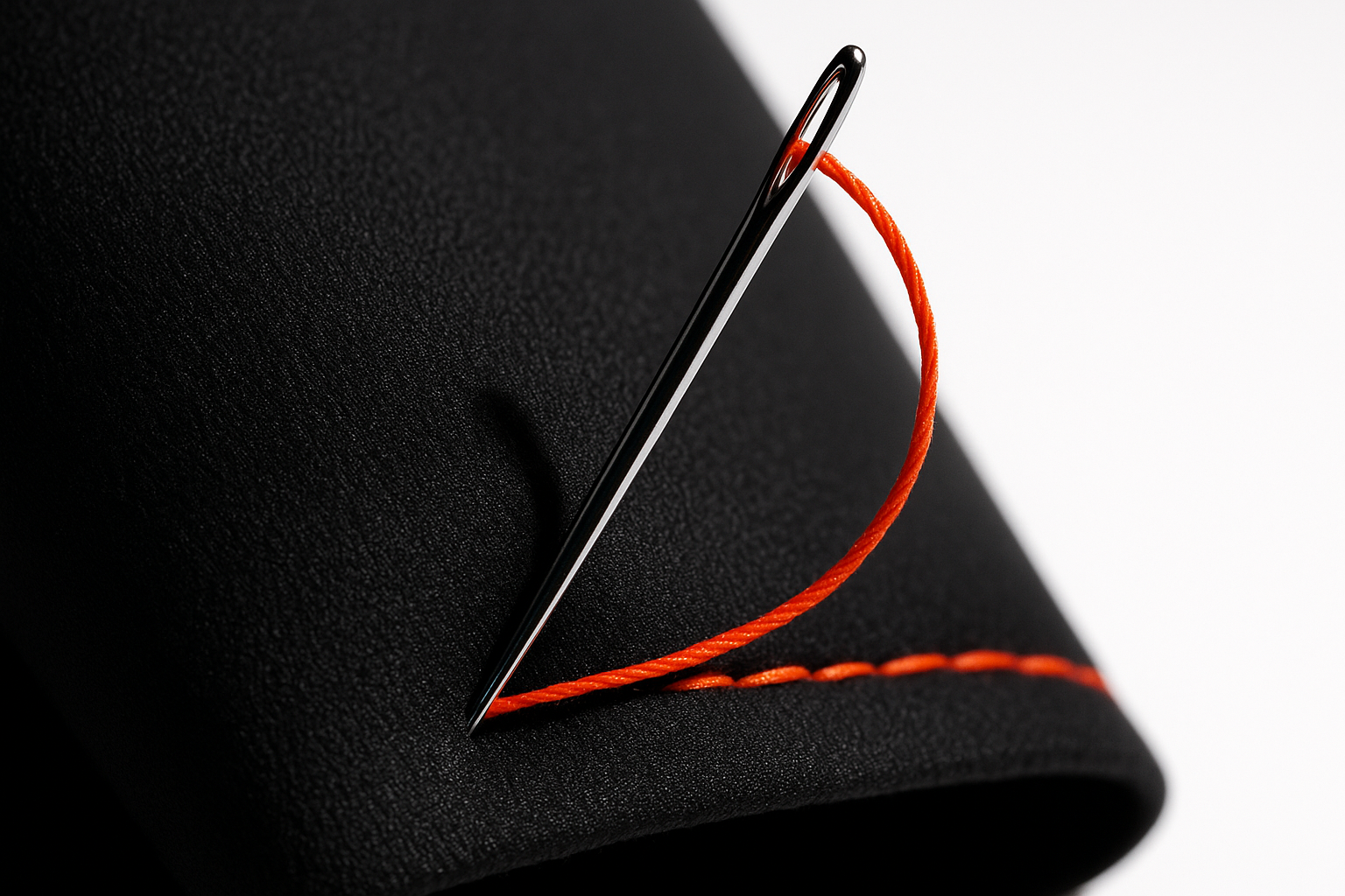 Orange thread stitched into black fabric